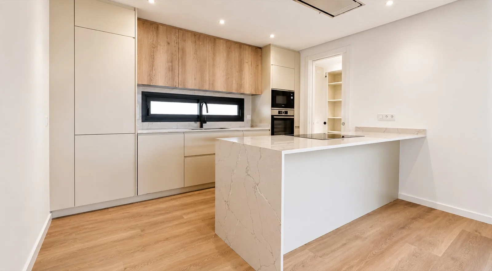 Cocina en blanco y roble con isla de mármol y office